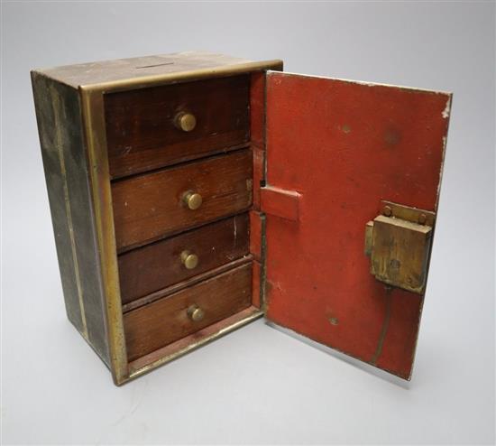 A brass money bank in the form of a safe, four drawers enclosed, height 21cm